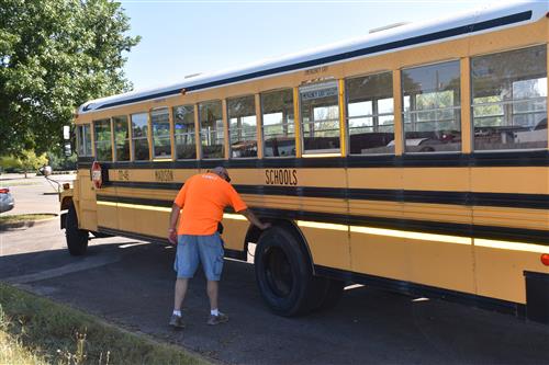 Driver inspecting bus tires 